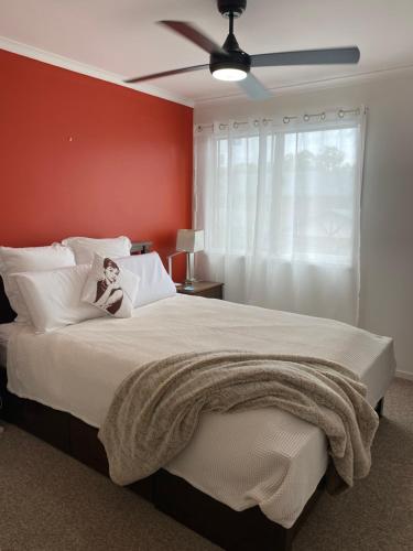 a bedroom with a large bed with a ceiling fan at Charming Townhouse Kirra Beach in Tweed Heads