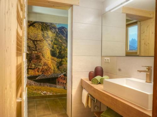 een badkamer met een wastafel en een schilderij aan de muur bij I in the Anton house in Obermaiselstein