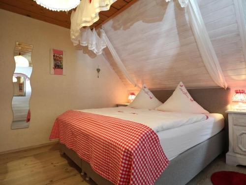 een slaapkamer met een bed met een rood-witte deken bij Haldenhäusle Black Forest in Oberschwärzenbach
