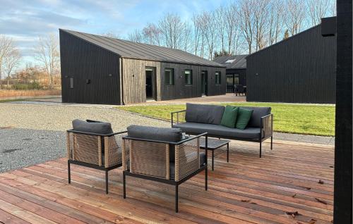 Dos sillas y un sofá en una terraza de madera. en 5 Bedroom Gorgeous Home In Karrebæksminde, en Enø By