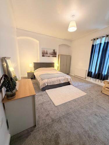 a large bedroom with a bed and a desk at Cosy Bungalow house in the centre of Sunderland in Sunderland