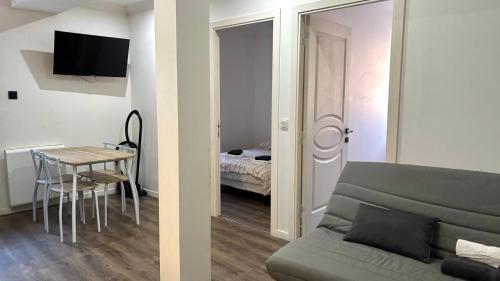 ein Wohnzimmer mit einem Sofa und einem Tisch sowie ein Schlafzimmer in der Unterkunft Luxueux t3 Aiguebelle in Randens