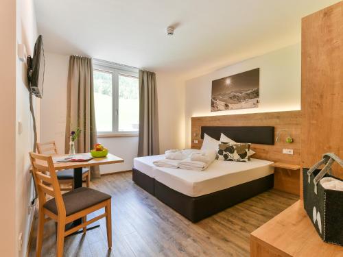 a hotel room with a bed and a desk at Alpine Lodge Klösterle am Arlberg in Klösterle am Arlberg