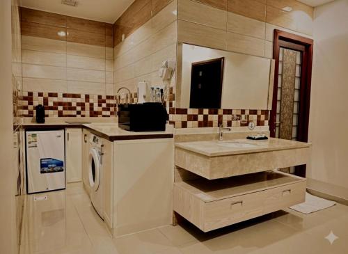 una cucina con lavandino e lavastoviglie di Quartz Executive - كوارتز التنفيذية a Abha