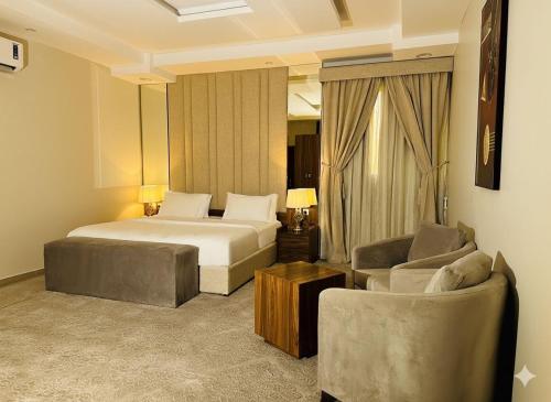 a bedroom with a bed and a couch and a chair at Quartz Executive - كوارتز التنفيذية in Abha