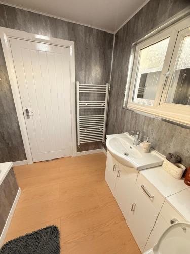 a bathroom with a white sink and a window at Cosy Bungalow house in the centre of Sunderland in Sunderland