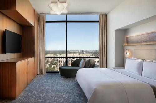 a hotel room with a bed and a large window at The Westin Galleria Dallas in Dallas
