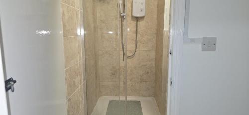 a shower with a glass door in a bathroom at The Brick Lane Suites London in London