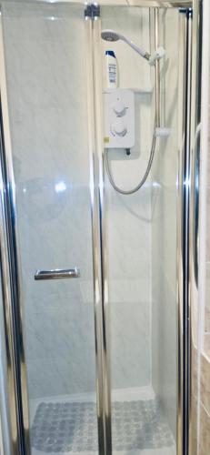 a shower with a glass door in a bathroom at The Brick Lane Suites London in London