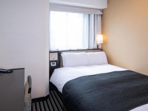 a hotel room with a bed and a window at APA Hotel Higashi Shinjuku Kabukicho in Tokyo