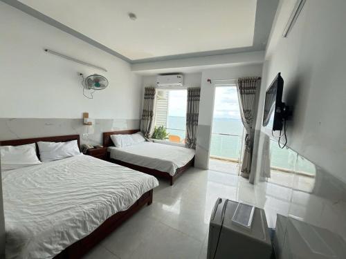 een hotelkamer met twee bedden en een raam bij Vi-vu Hotel Quy Nhơn in Quy Nhon