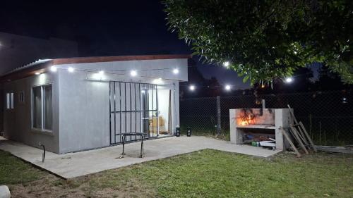 un piccolo edificio con un camino in un cortile di notte di El Campito 2 a Necochea