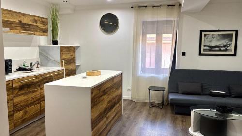 a kitchen and a living room with a couch at Spacieux T3 aiguebelle in Randens