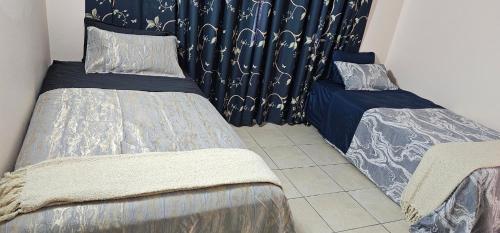 a room with two beds and a curtain at Heart of Townsville tranquillity in Ross River