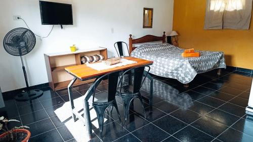 een kamer met een bed en een tafel met een bureau bij Nuestro Lugar in El Bolsón