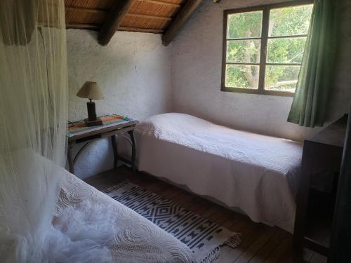 a bedroom with two beds and a desk and a window at QinLing, El color del Espíritu in Playa Hermosa