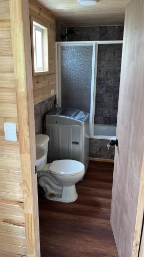 un piccolo bagno con servizi igienici e finestra di Cabañas a Quemchi