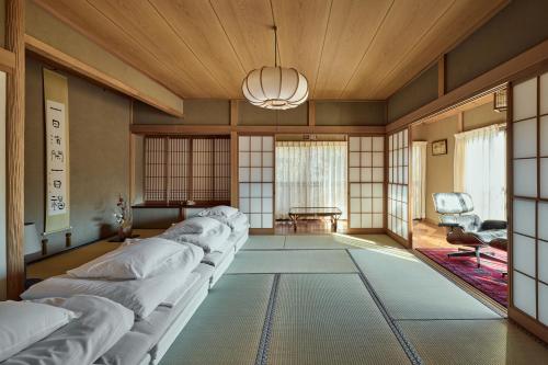 a living room with white couches and a wooden ceiling at 千日箱根 SEN-NICHI Hakone 大涌谷を望む絶景宿 in Hakone