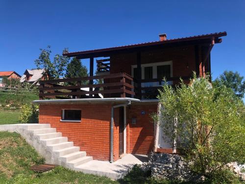 ein Backsteinhaus mit einem Balkon darauf in der Unterkunft Mountain resort house - Planinska vikendica in Han Pijesak