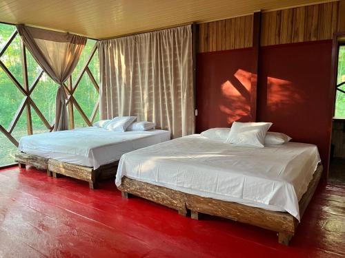 2 letti posti in una stanza con finestre di Tekuna a Leticia