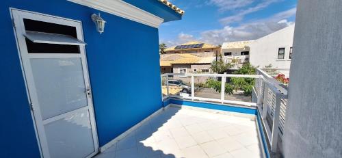 einen Balkon mit blauer Wand und Tür in der Unterkunft Fantástica Casa 03 Quartos nas belíssimas Praias do Flamengo in Salvador