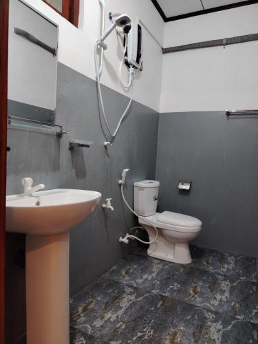a bathroom with a toilet and a sink and a shower at JAGA HOME in Tangalle