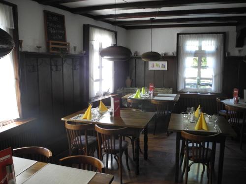 a restaurant with wooden tables and chairs and windows at Paciello Restaurant Hotel in Velbert