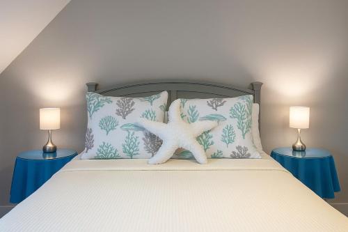 a bed with two pillows and a starfish on it at Ocean Pearl in Kill Devil Hills
