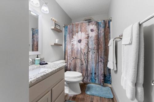 ein Badezimmer mit Toilette und Duschvorhang in der Unterkunft Bella Vita - Pet Friendly Cabin in Maggie Valley