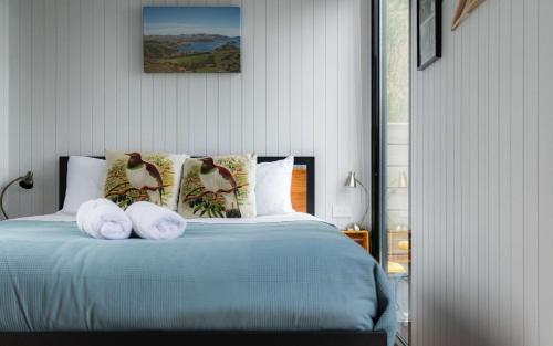 een slaapkamer met een bed met handdoeken erop bij Kūkupa Puni at Akaroa Lavender by Tiny Away in Akaroa