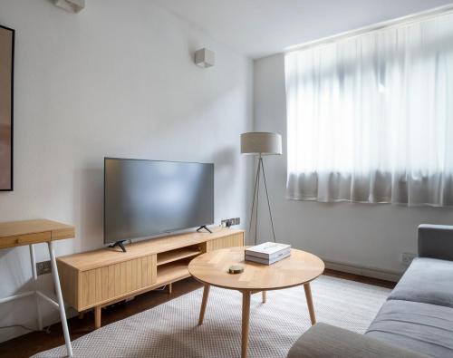 a living room with a large flat screen tv at Amazing 3 Bedrooms in Mayfair in London