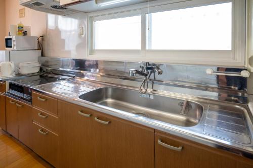 a kitchen with a stainless steel sink and a window at stay in tokiwa in Asahikawa