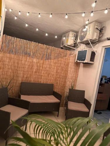 a patio with two chairs and a couch and a heater at Twin Towers Tres Mares in Acapulco