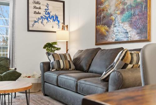 a living room with a brown leather couch at Modern Fishing Lodge 8ppl in Branson