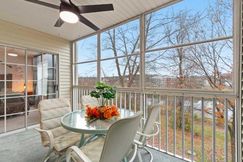 a screened in porch with a glass table and chairs at Modern Fishing Lodge 8ppl in Branson
