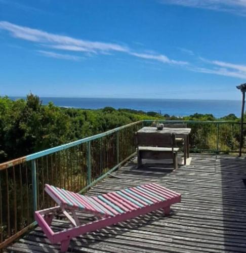 une terrasse en bois avec une table et un banc. dans l'établissement Refugio Kallfuko, a great space with nature, à Valdivia