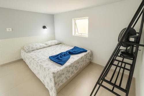 a bedroom with a bed with a blue blanket on it at Loft central perto da praia in Caraguatatuba