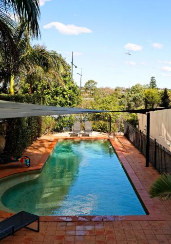a swimming pool in a yard with a patio at Founda Gardens Apartments in Brisbane