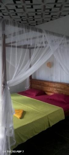 a bedroom with a bed with a mosquito net at Villa Tharu in Hikkaduwa