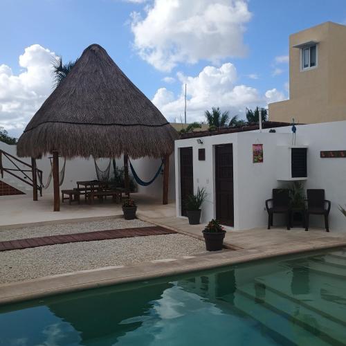 a villa with a swimming pool and a building at Casa Loto A in Chelem