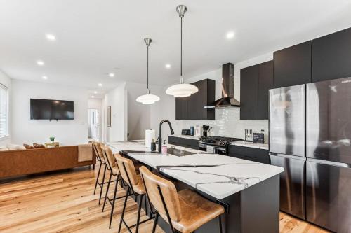 a kitchen with a large island with bar chairs at Modern 3BR Walk to Museums in Philadelphia