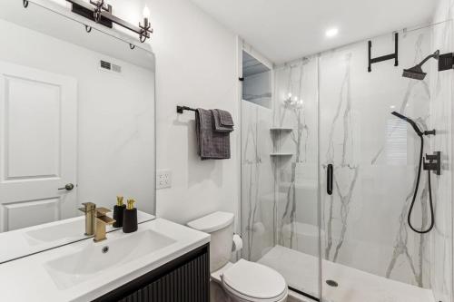 a white bathroom with a shower and a toilet at Modern 3BR Walk to Museums in Philadelphia