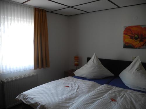 a bedroom with a bed and a window at Paciello Restaurant Hotel in Velbert