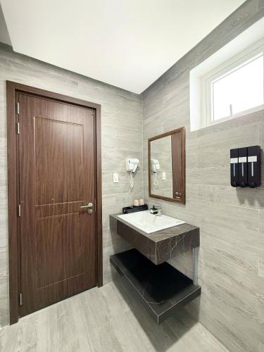 a bathroom with a sink and a wooden door at KIEN DALAT - Nguyễn Hữu Cảnh in Da Thien