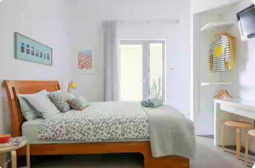a white bedroom with a bed and a window at Fremantle Harbour Studio in Fremantle
