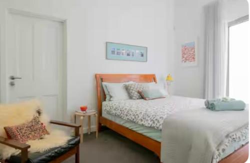 une chambre avec deux lits et une chaise et une fenêtre dans l'établissement Fremantle Harbour Studio, à Fremantle