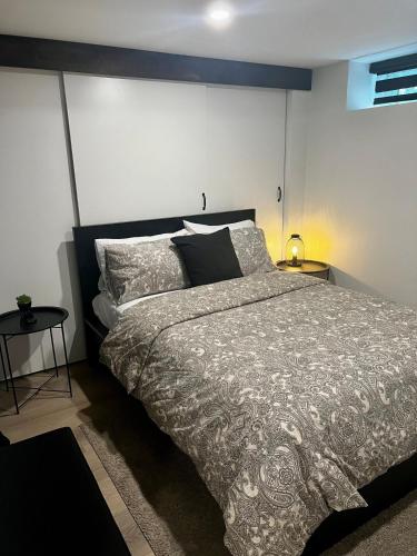 a bedroom with a large bed and two tables at Edinburgh in Drummondville