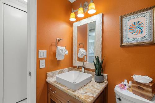 een badkamer met een wastafel en een spiegel bij Lahaina Shores PH3 in Wainee