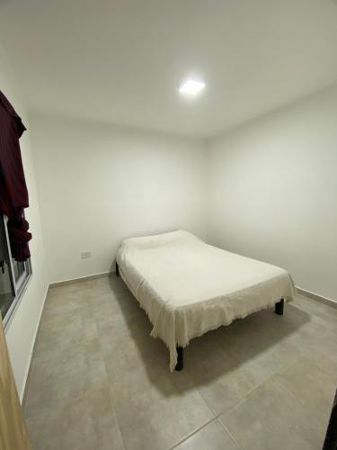 Posto letto in camera con parete bianca di Quintas Baradero a Baradero