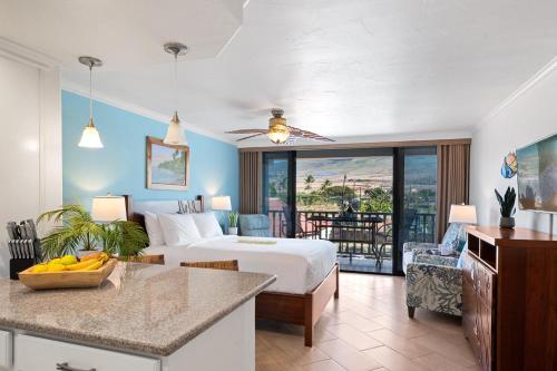 a hotel room with a bed and a kitchen with a table at Lahaina Shores 212 in Lahaina